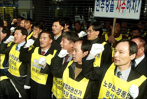 서울지검 특수2부의 수사관들이 한화갑 전대표에 대한 구속영장을 집행하기 위해 1일 오전 서울 여의도 민주당사에 도착하자, 당직자들과 당원들이 광주출정가를 개사한 노래를 부르며 저지하고 있다. 